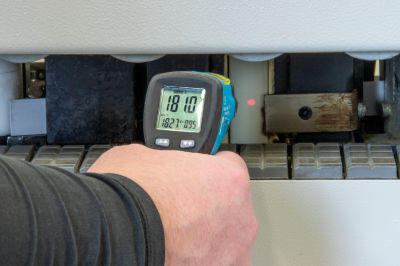 An image of an engineer temperature-checking an edgebander