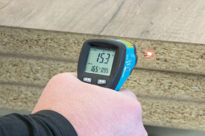 An image of an engineer temperature-checking a board